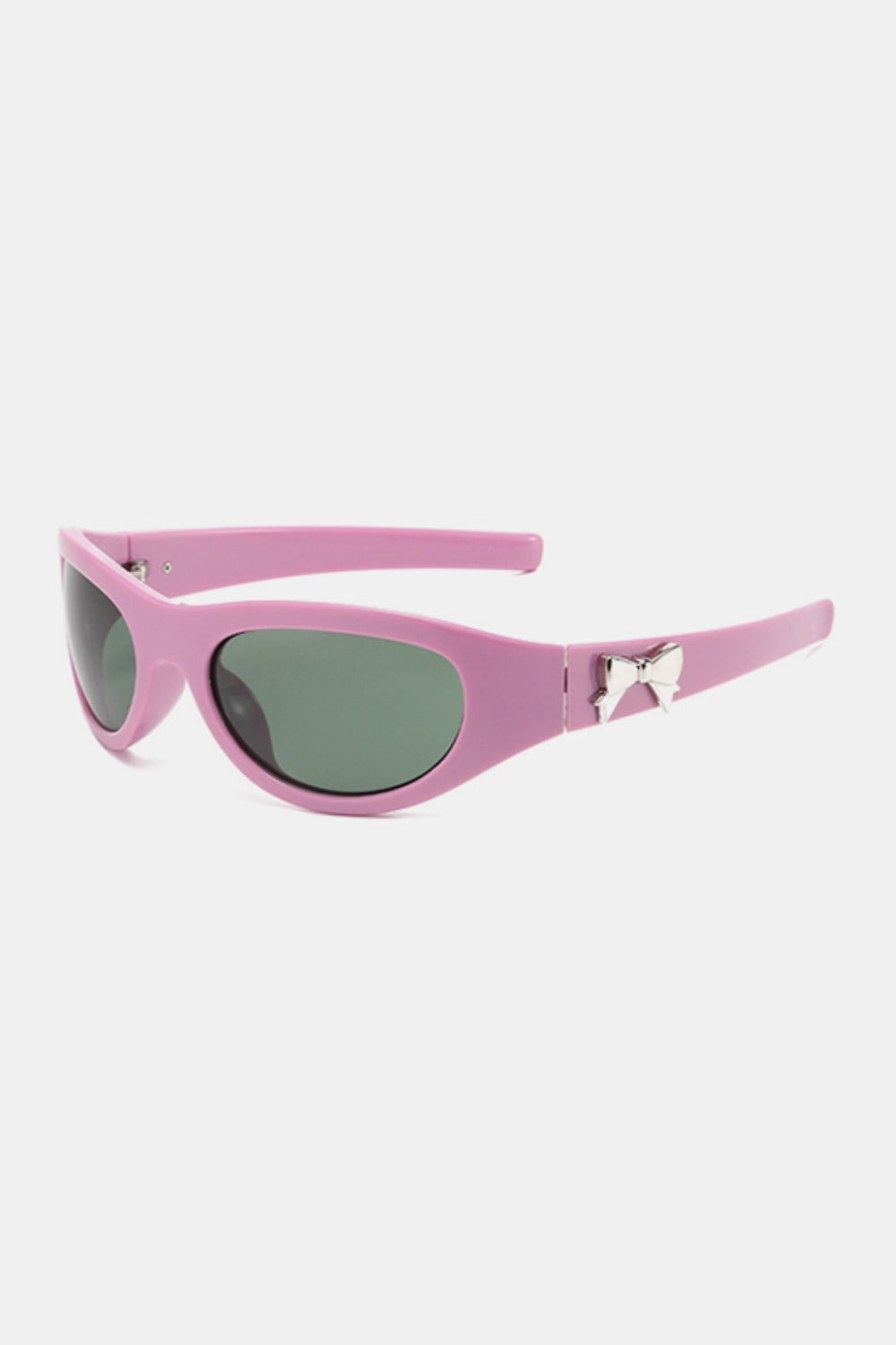 Pink polycarbonate cat-eye sunglasses feature a softly upswept frame, rounded dark lenses, tapered temples, and a polished bow accent at each side.