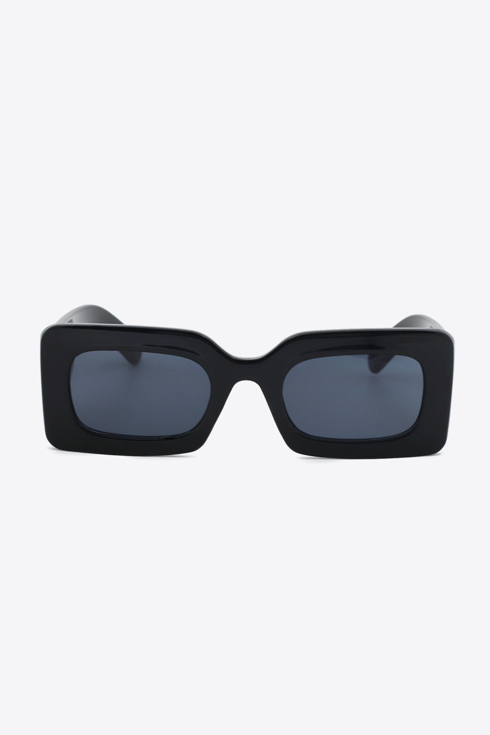 Black polycarbonate rectangle sunglasses shown front-facing with softly rounded dark lenses, a bold structured frame, and substantial sculptural temples.