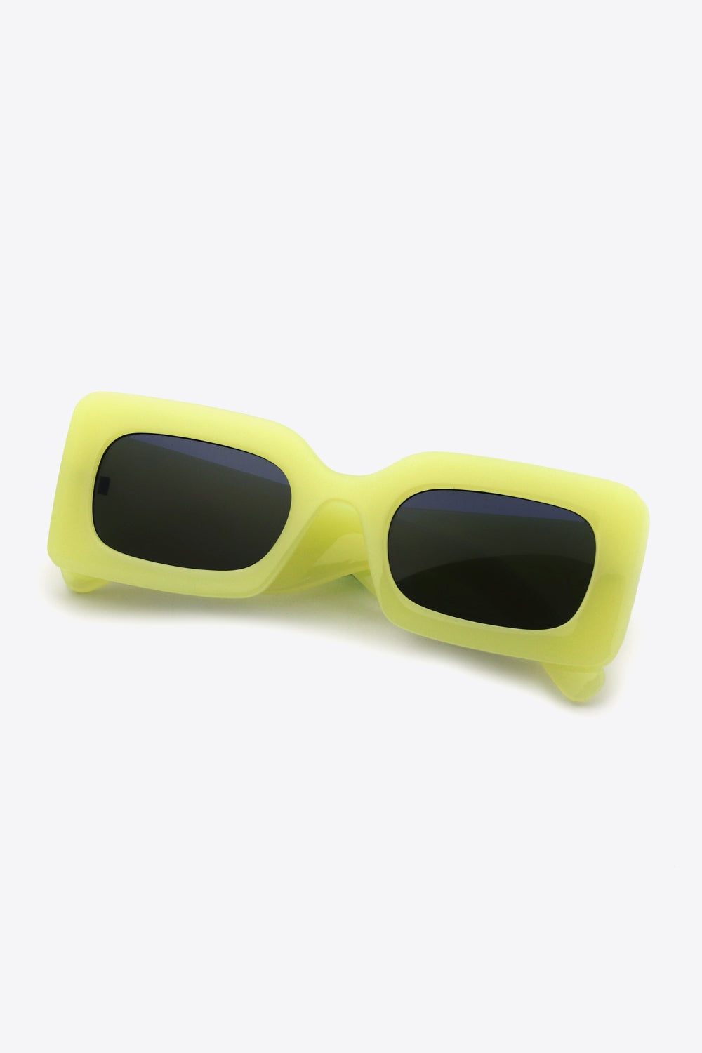 Bright yellow-green polycarbonate rectangle sunglasses feature softly rounded frames, dark lenses, a bold structured silhouette, and substantial sculptural temples.