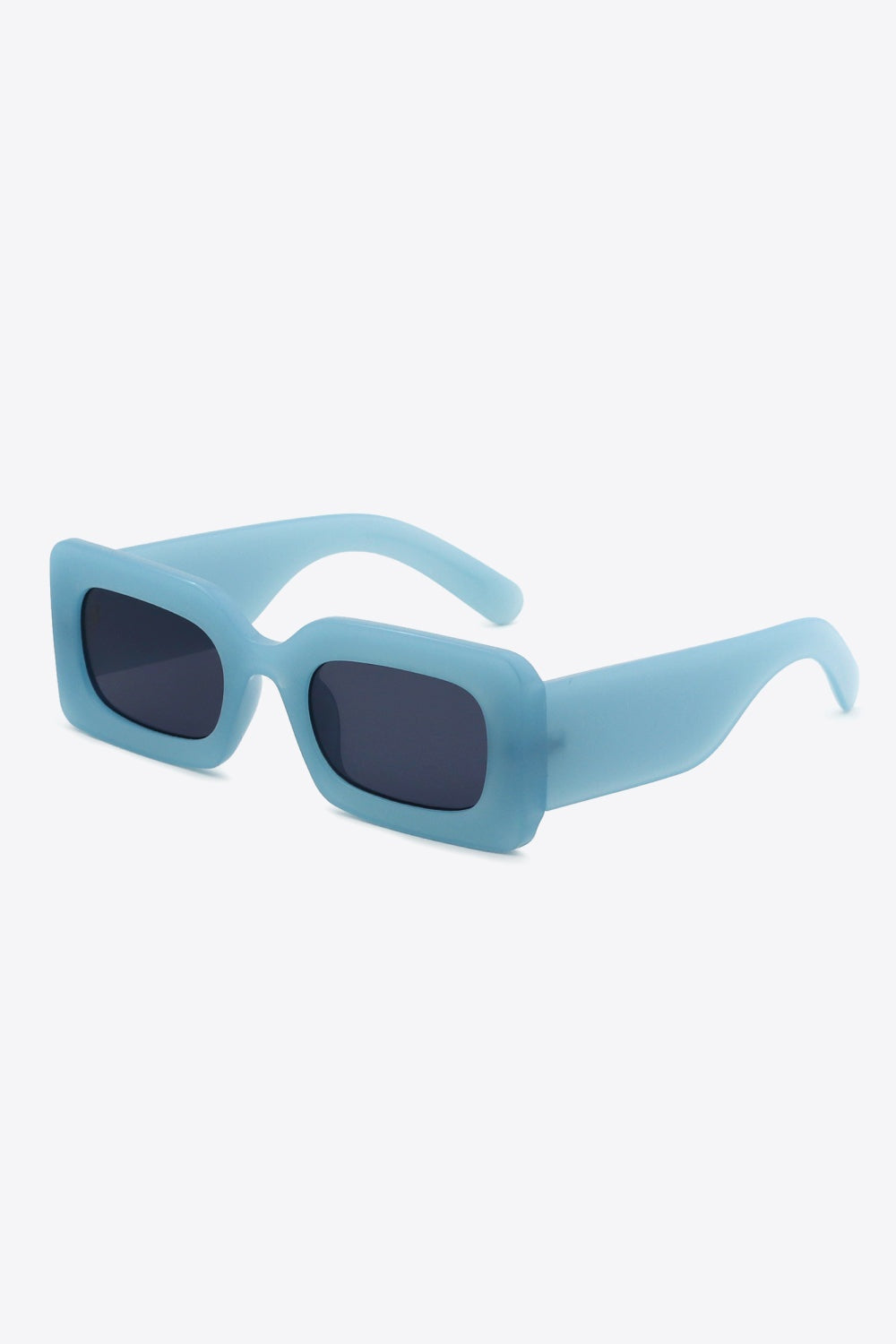 Blue polycarbonate rectangle sunglasses feature softly rounded dark lenses, a bold chunky frame, and substantial sculptural temples shown in an angled view.