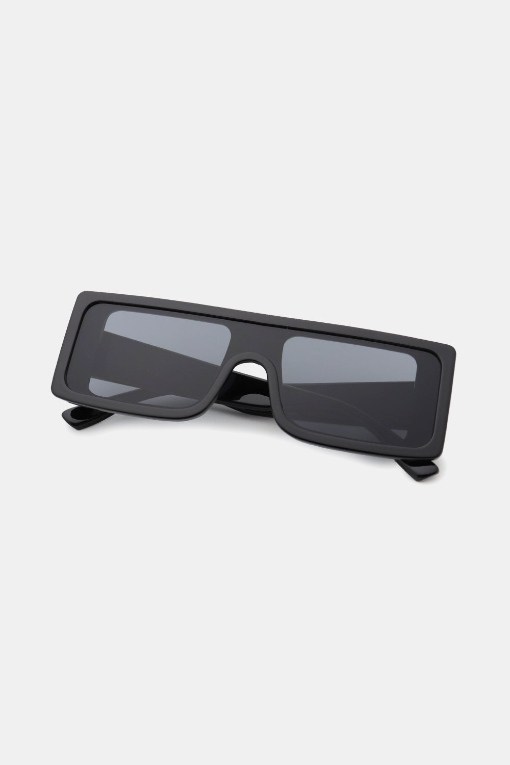 Black polycarbonate rectangle sunglasses feature a broad, squared frame, dark lenses, and a sleek streamlined silhouette with folding temples.