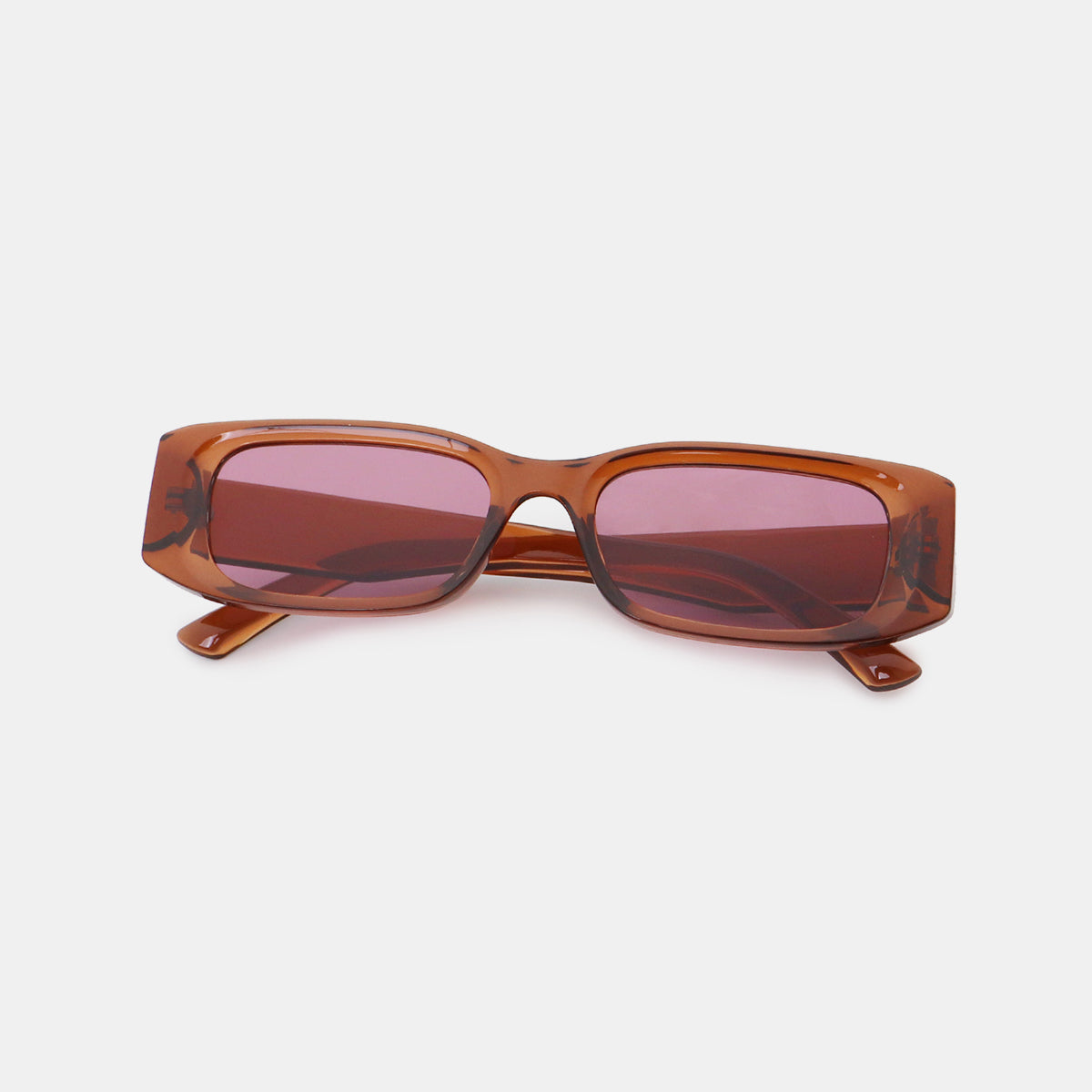 Translucent amber polycarbonate rectangle sunglasses feature broad squared frames, softly rounded corners, wide temples, and pink-tinted lenses.