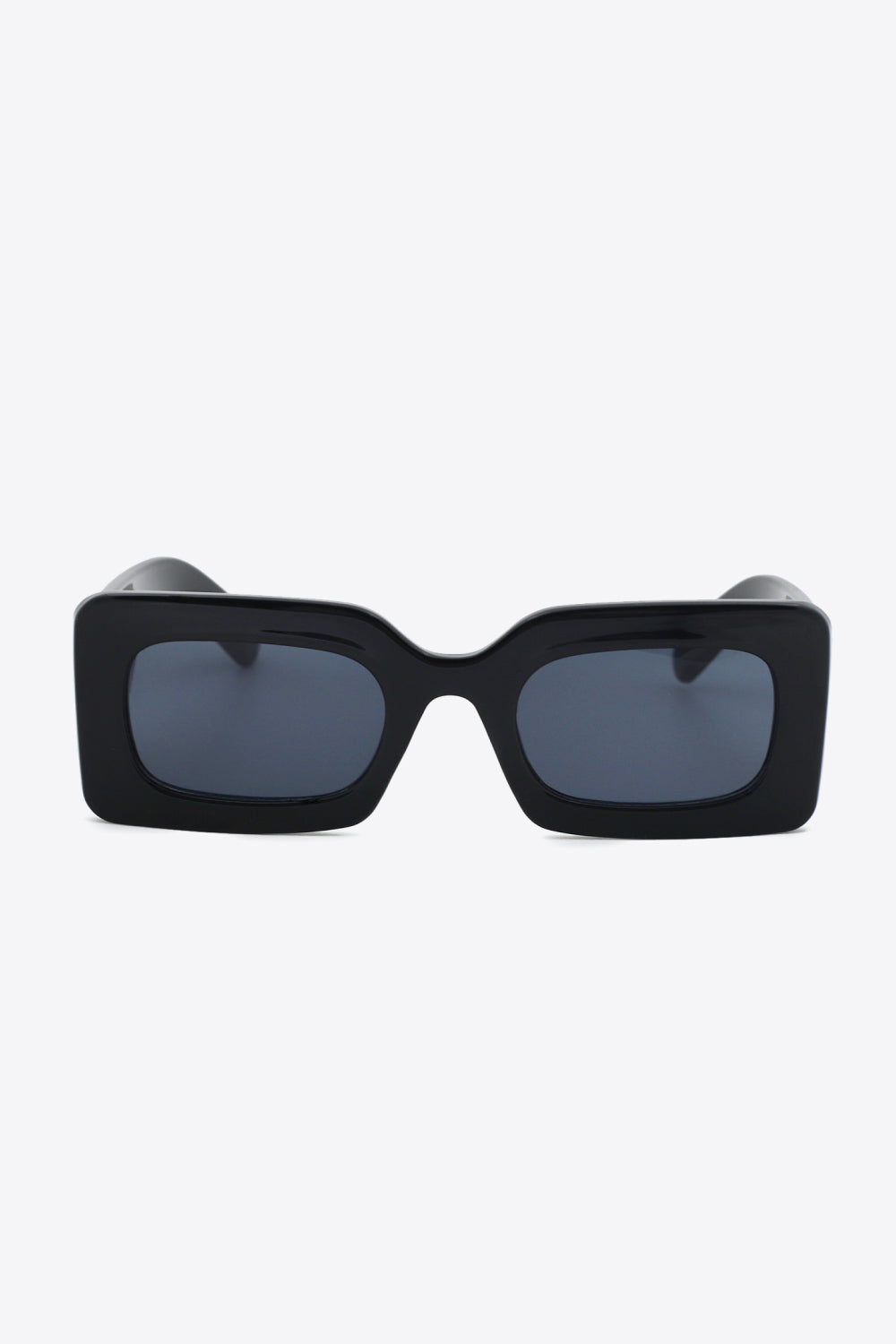 Black polycarbonate rectangle sunglasses shown front-facing with softly rounded dark lenses, a bold structured frame, and substantial sculptural temples.
