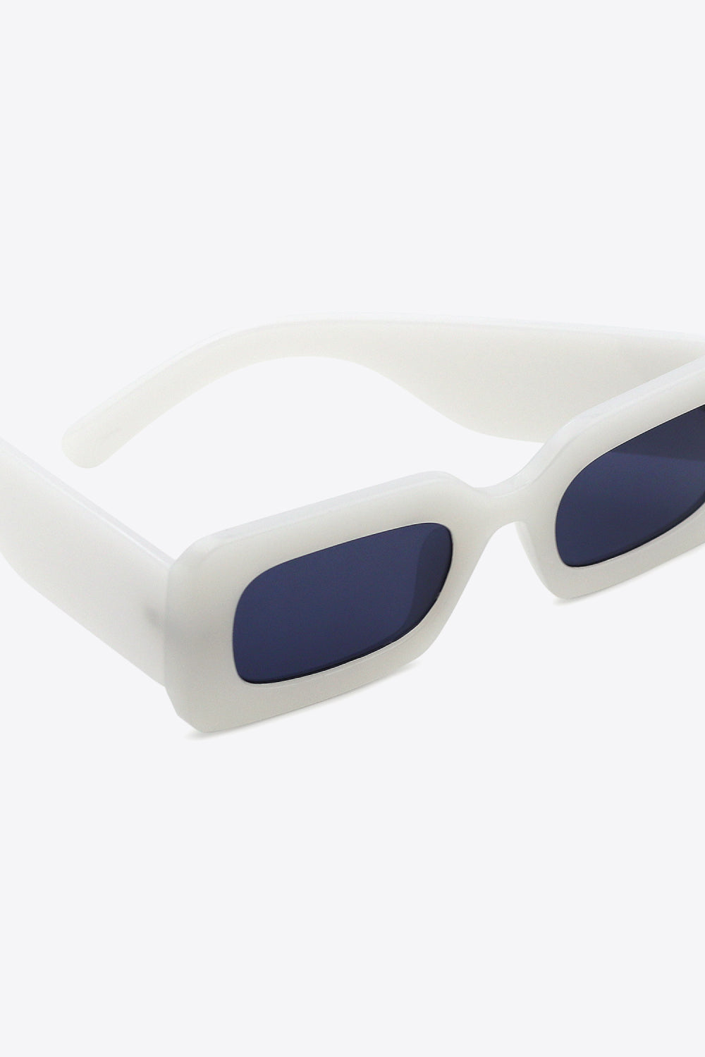 White polycarbonate rectangle sunglasses feature softly rounded frames, dark lenses, and substantial sculptural temples for a bold, modern silhouette.