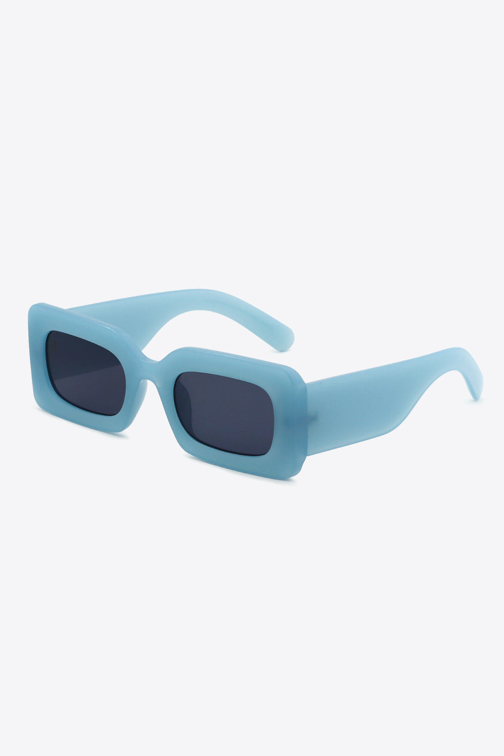 Blue polycarbonate rectangle sunglasses feature softly rounded dark lenses, a bold chunky frame, and substantial sculptural temples shown in an angled view.