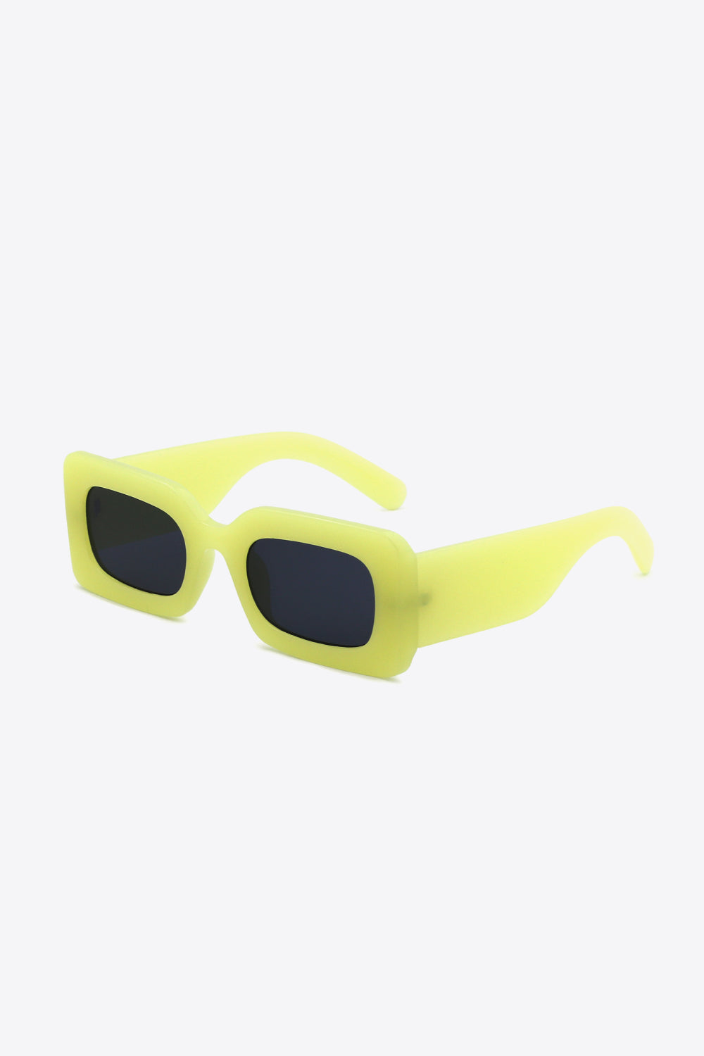 Bright yellow polycarbonate rectangle sunglasses feature softly rounded dark lenses, a bold frame, and wide sculptural temples shown at an angled view.