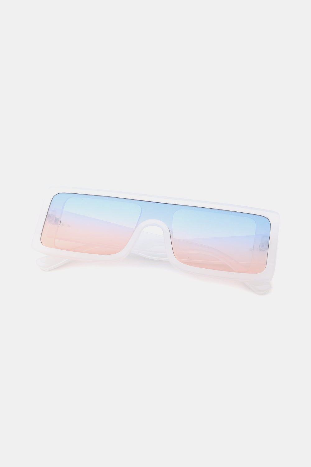 Translucent white polycarbonate rectangle sunglasses feature a broad, squared frame, oversized blue-to-pink gradient lenses, and streamlined temples.