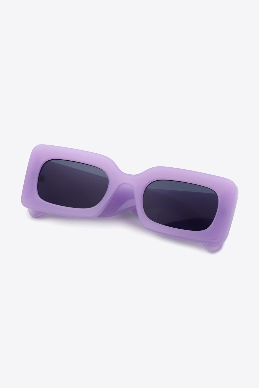 Lavender polycarbonate rectangle sunglasses feature softly rounded frames, dark lenses, a sculptural bridge, and substantial temples for a bold modern silhouette.