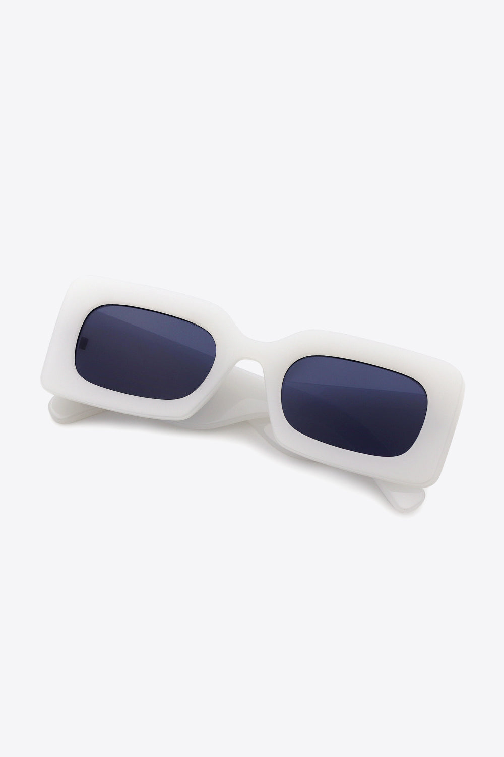 White polycarbonate rectangle sunglasses feature softly rounded dark lenses, a substantial sculptural frame, and thick temples for a bold modern silhouette.