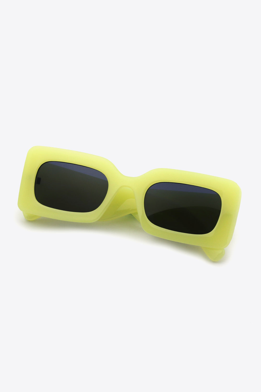Bright yellow-green polycarbonate rectangle sunglasses feature softly rounded frames, dark lenses, a bold structured silhouette, and substantial sculptural temples.