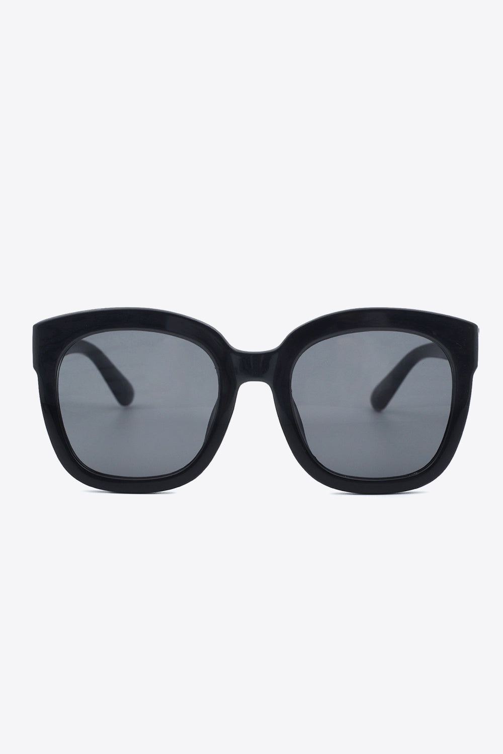 Bold black polycarbonate square sunglasses feature a softly rounded silhouette, substantial frame, matching temples, and generous gray acetate lenses.