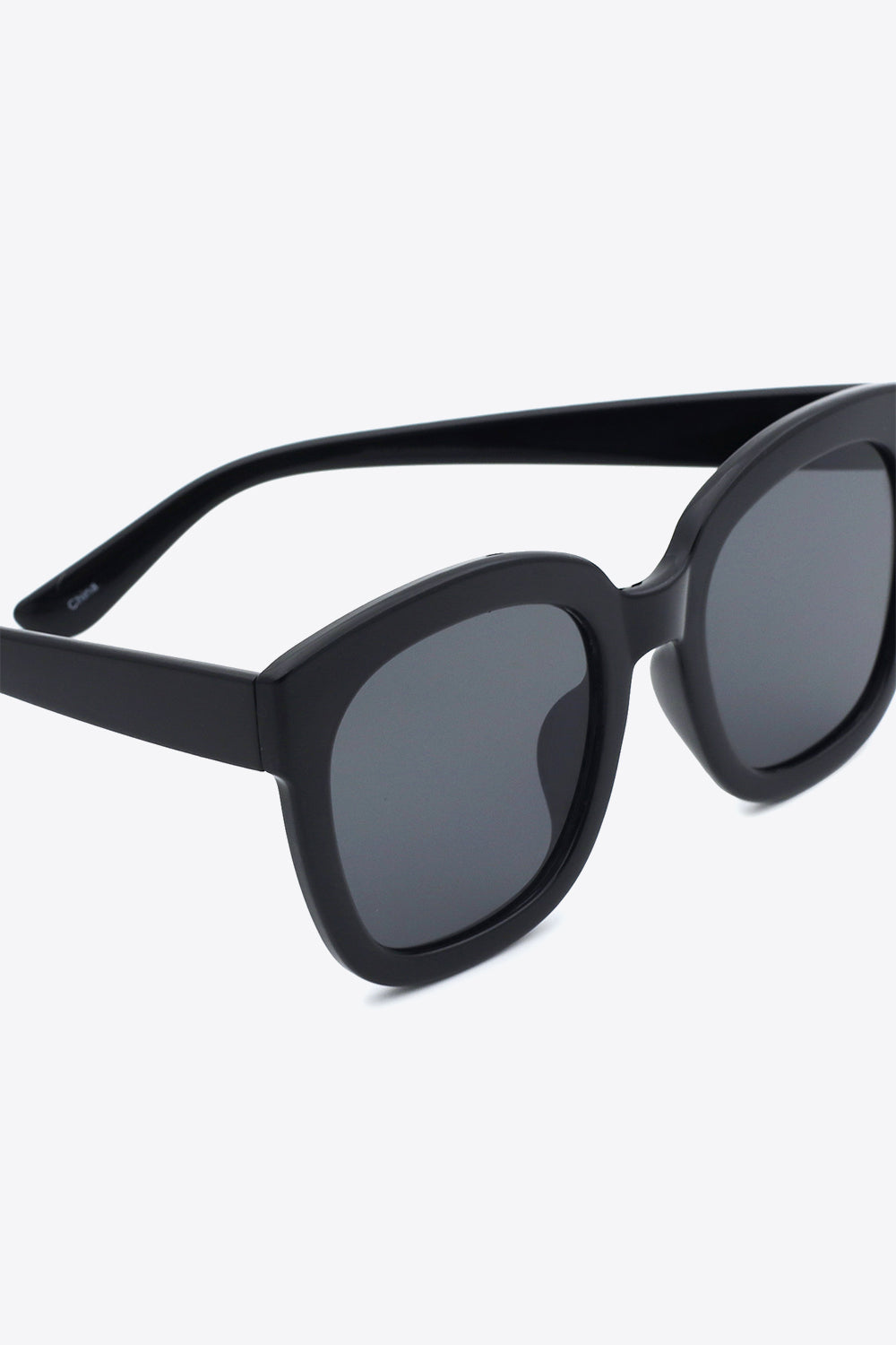 Black polycarbonate frame square sunglasses feature a bold, softly rounded silhouette, substantial temples, and dark acetate lenses for balanced coverage.