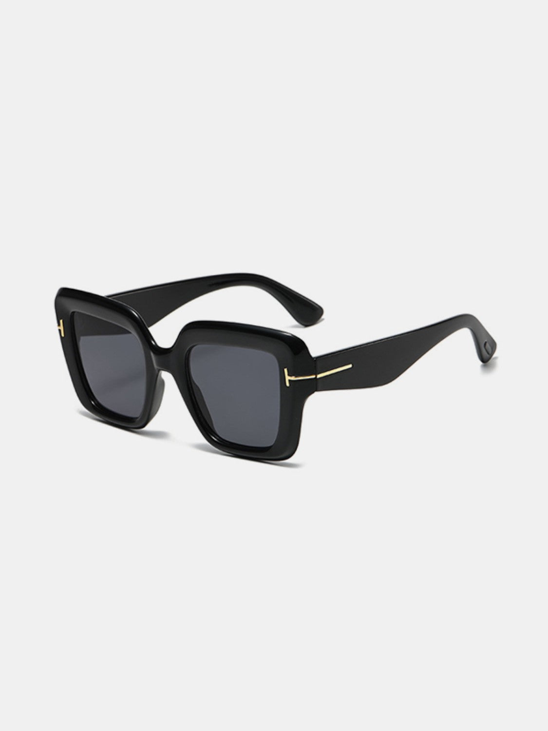 Black polycarbonate square sunglasses feature softly rounded frames, dark lenses, broad temples, and subtle gold-tone hinge accents.