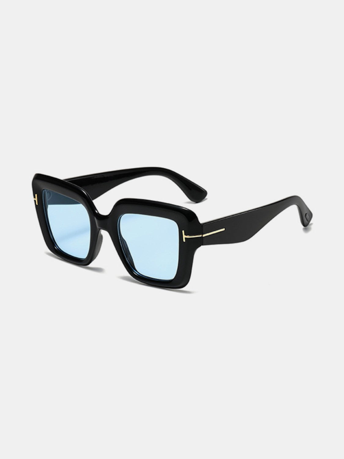Black polycarbonate square sunglasses feature softly rounded frames, broad temples, blue-tinted lenses, and subtle gold-tone hinge accents.