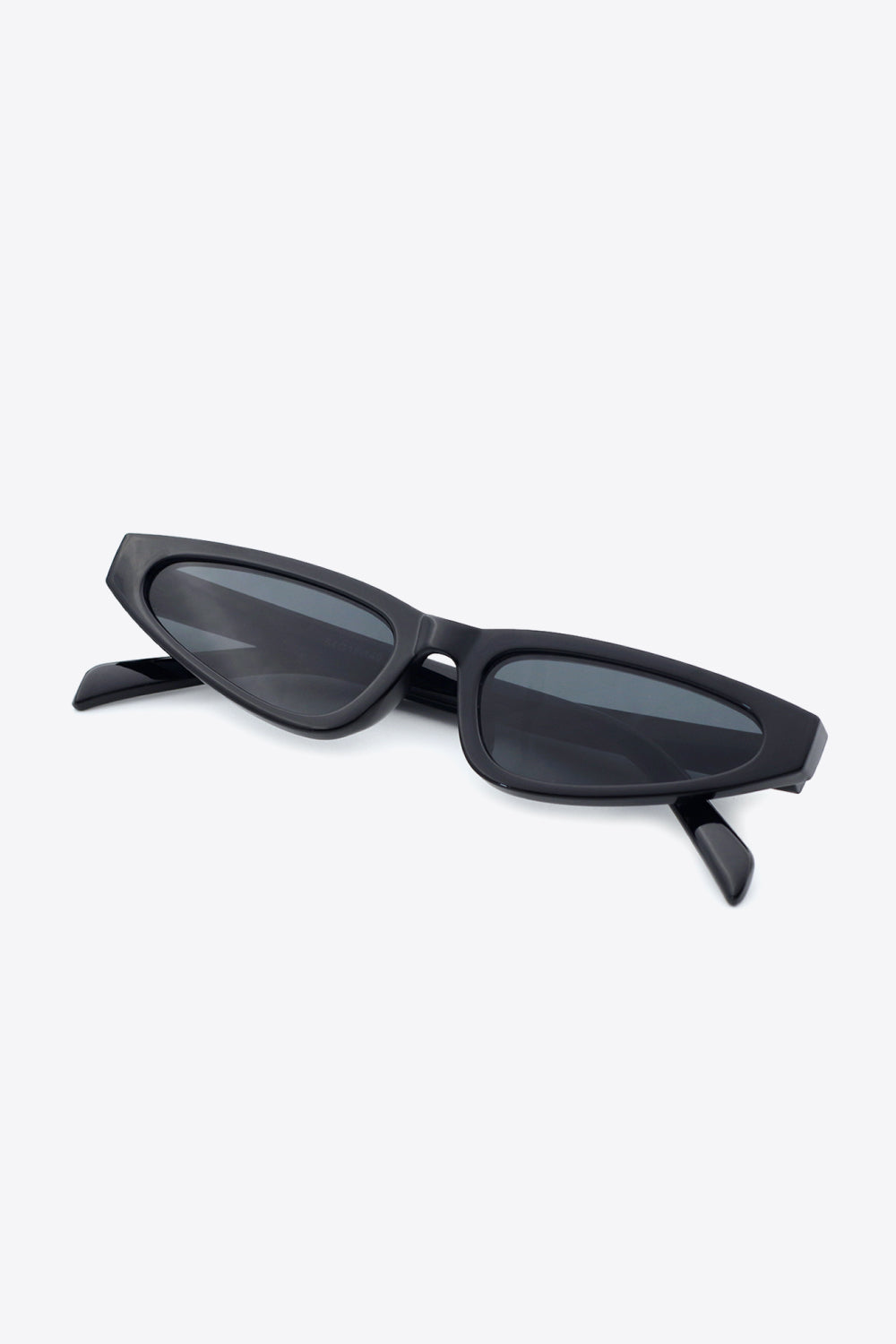 Black polycarbonate cat-eye sunglasses with dark acetate lenses feature a sleek, gently upswept silhouette and matching structured temples.
