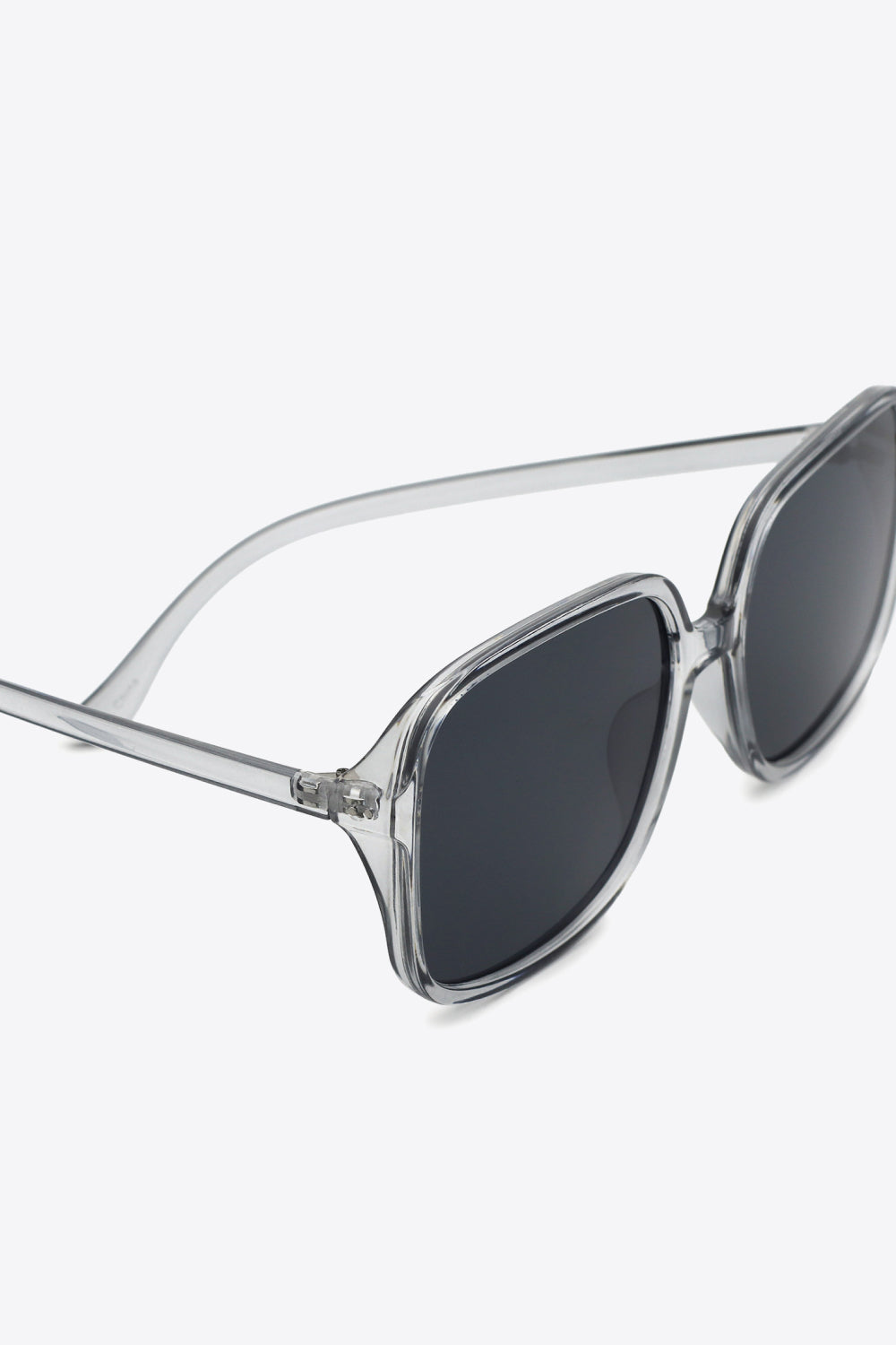 Translucent gray polycarbonate square sunglasses feature broad dark lenses, softly rounded frames, a defined top line, and sleek slim temples.