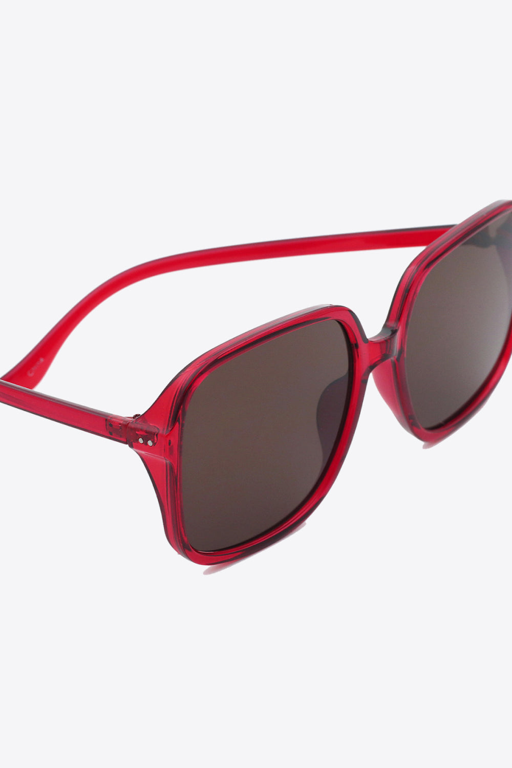 Translucent red polycarbonate square sunglasses feature softly rounded frames, broad dark lenses, a defined top line, and substantial streamlined temples.