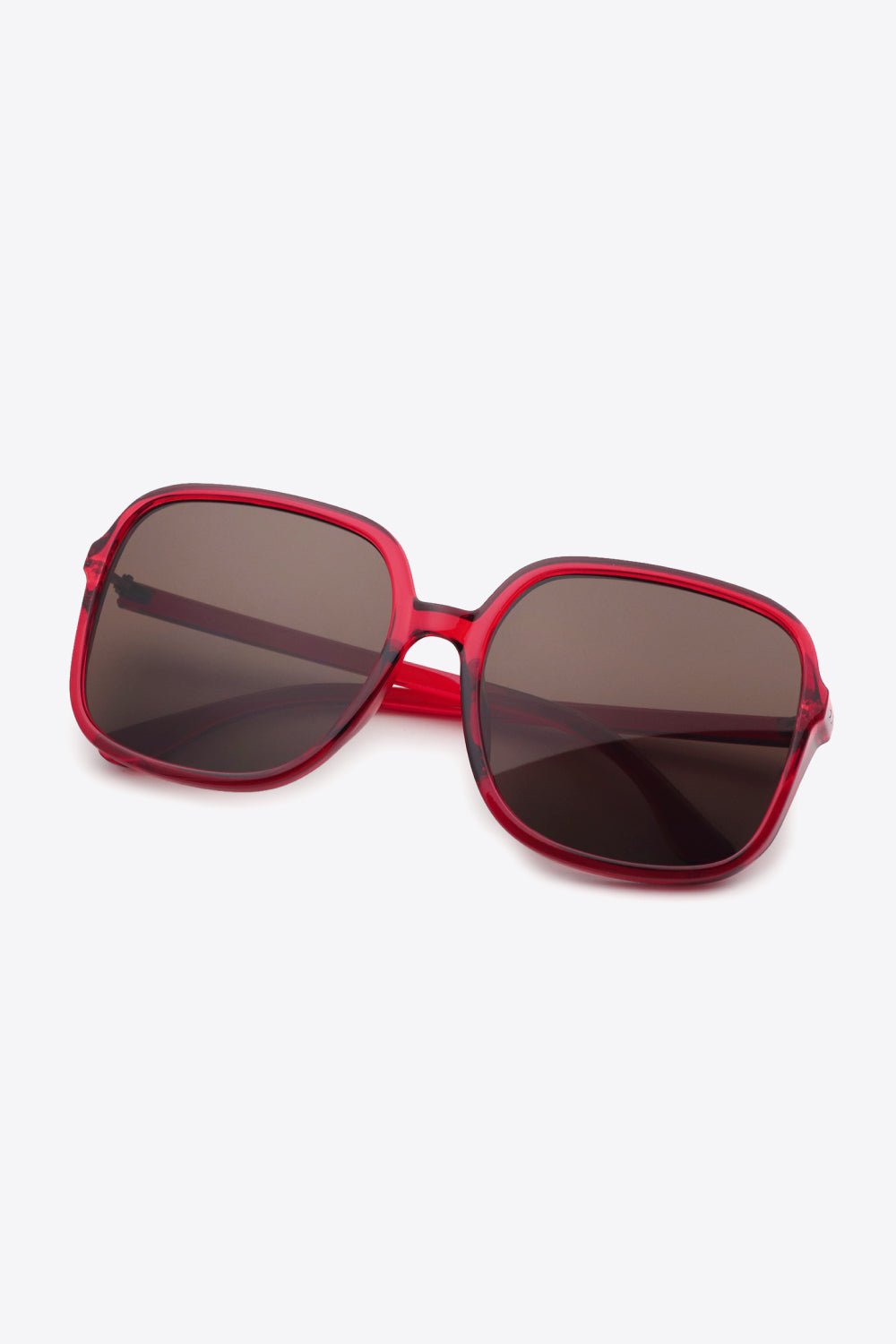 Red polycarbonate square sunglasses with softly rounded frames, broad brown lenses, a defined top line, and sleek temples create a bold, polished silhouette.