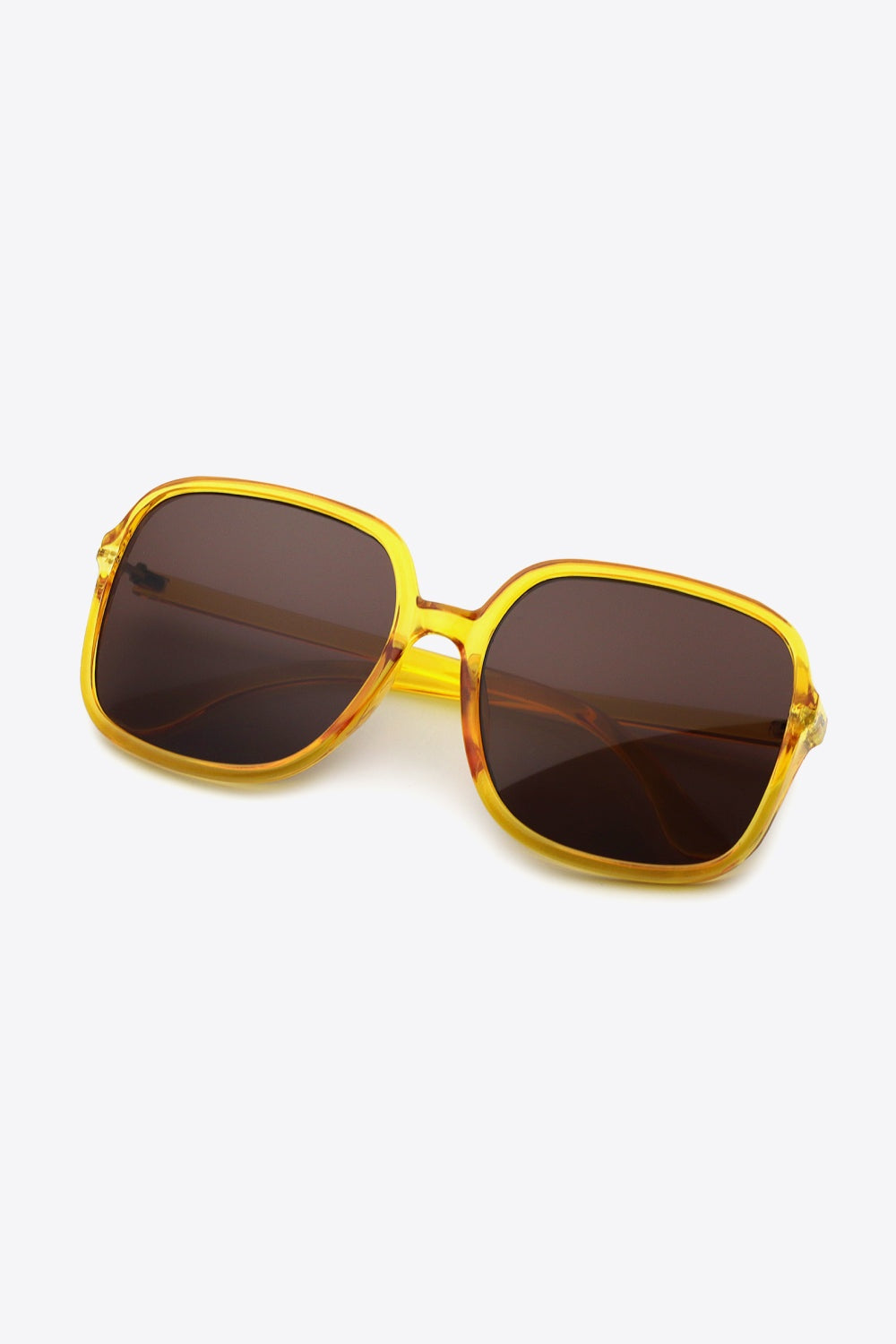 Polycarbonate square sunglasses with a translucent amber-yellow, softly rounded frame, broad dark brown lenses, a defined top line, and sleek matching temples.