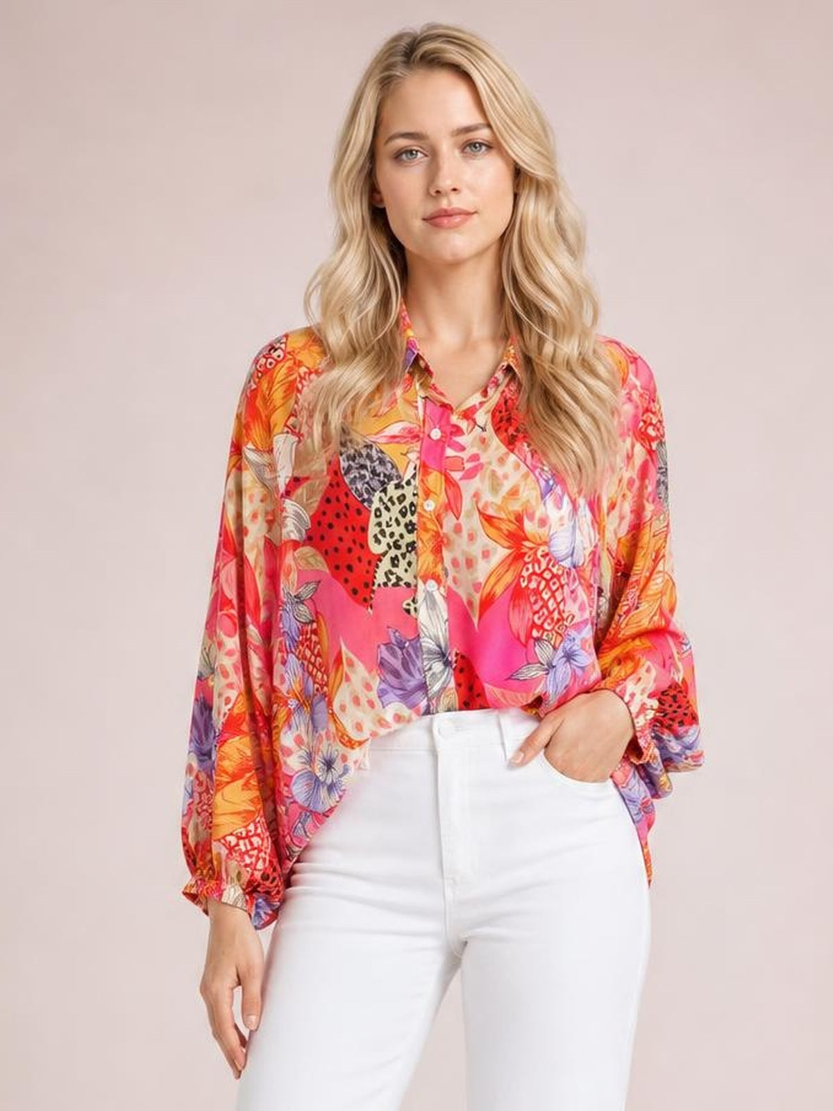 Model wearing a colorful printed button-down long-sleeve shirt with a collared neckline, front buttons, relaxed silhouette, and floral pattern.