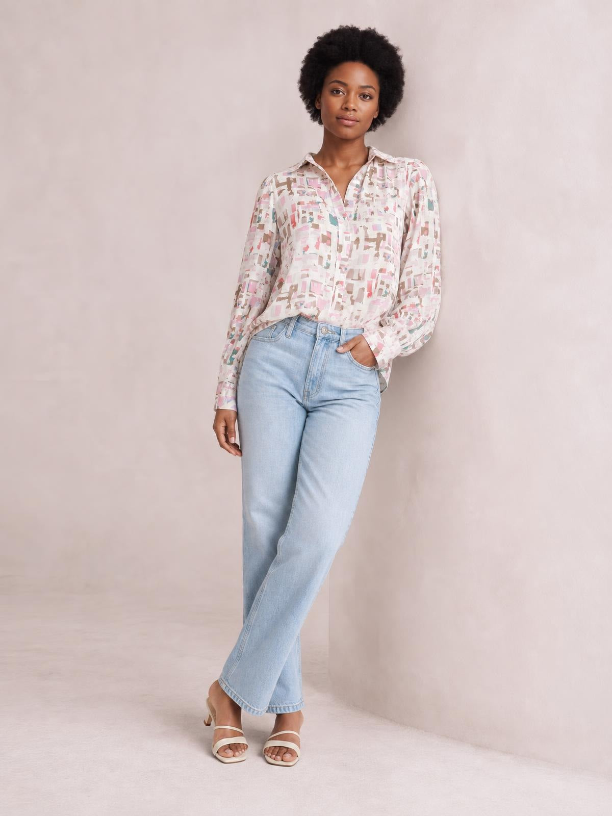 Model wears a pastel printed collared neck long sleeve shirt with a relaxed silhouette, button-front construction, and cuffs, paired with light-wash jeans.