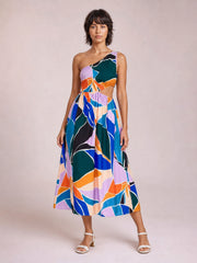 Model poses in a colorful printed one-shoulder sleeveless dress with a waist cutout, fitted bodice, and softly flared midi-length skirt.