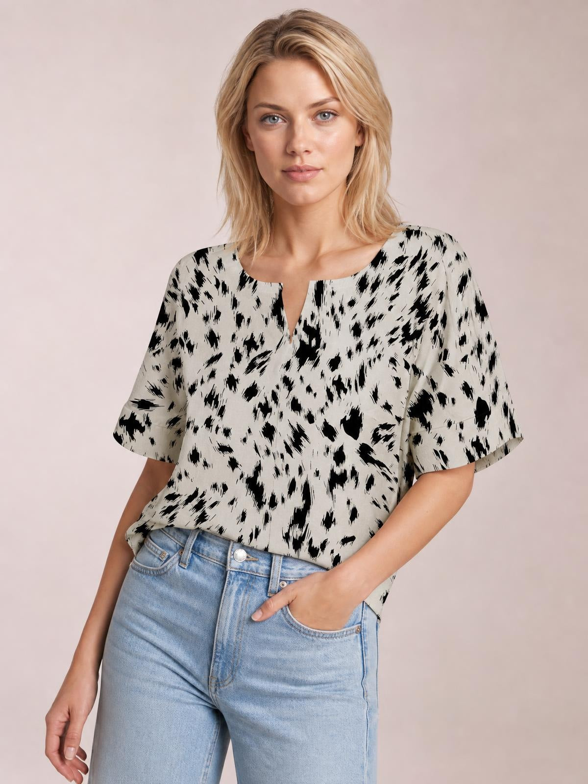A model wears a chic black-and-white printed blouse with a notched neckline, regular half sleeves, and a relaxed regular-length silhouette.
