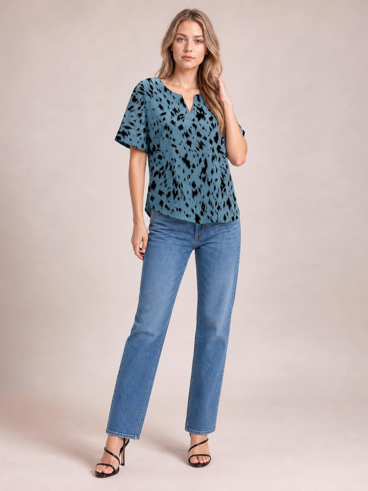 Model poses in a blue printed blouse with a notched neck, regular half sleeves, and a relaxed regular-length silhouette.