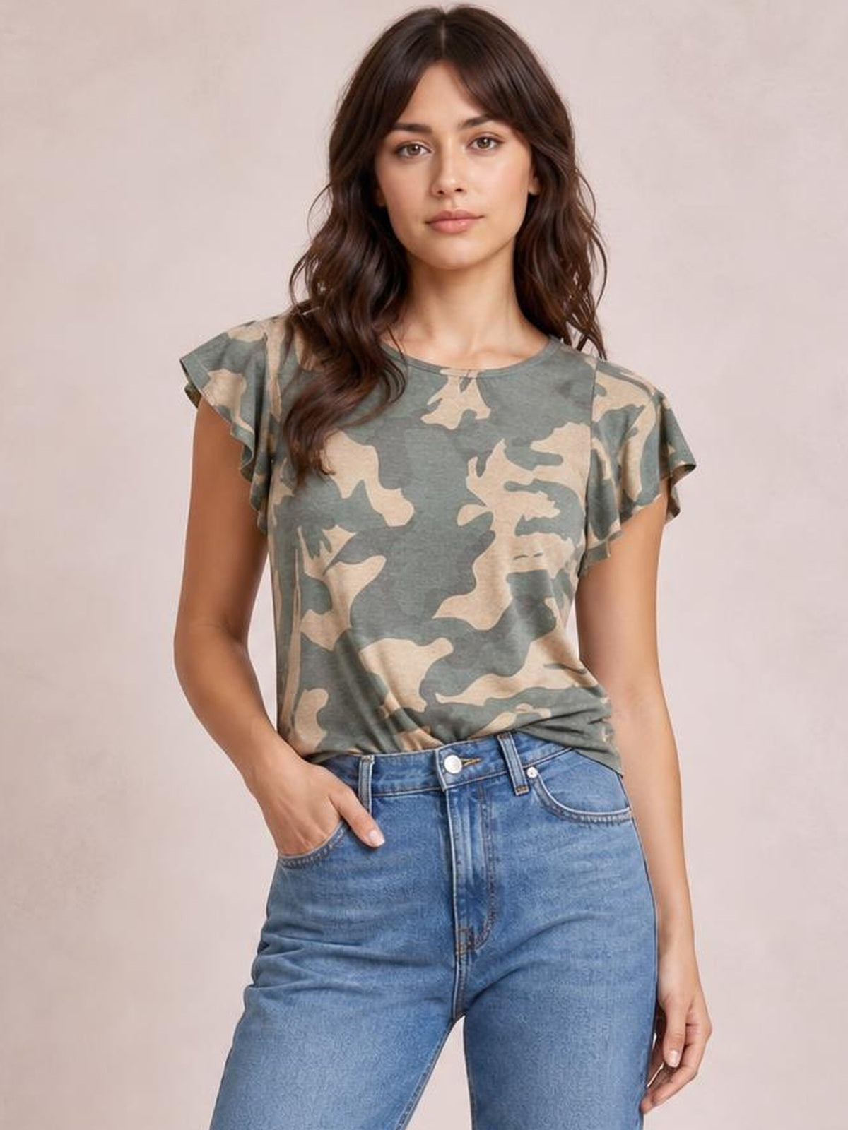 Model poses with one hand in her jeans pocket, wearing a gray and beige camouflage-print round-neck short-sleeve T-shirt with a relaxed silhouette.