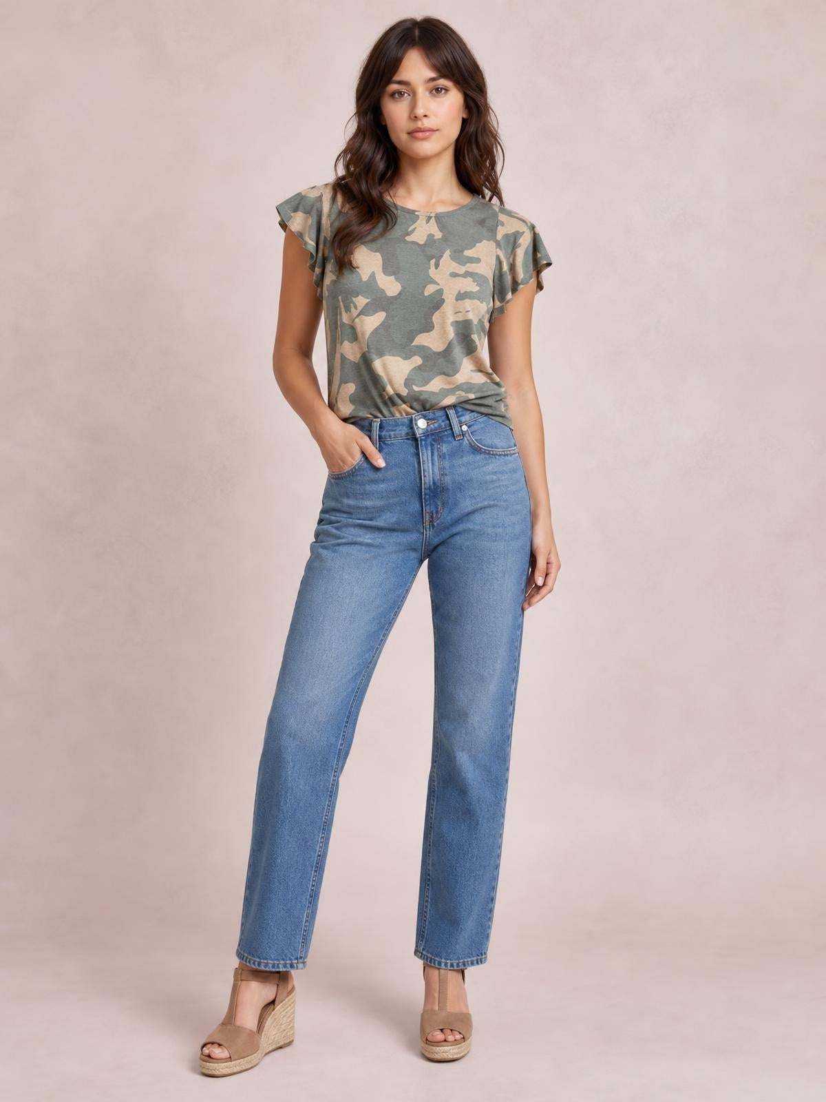 A model poses with one hand in her jeans pocket wearing a gray-green camouflage printed round-neck short-sleeve T-shirt with a relaxed silhouette.
