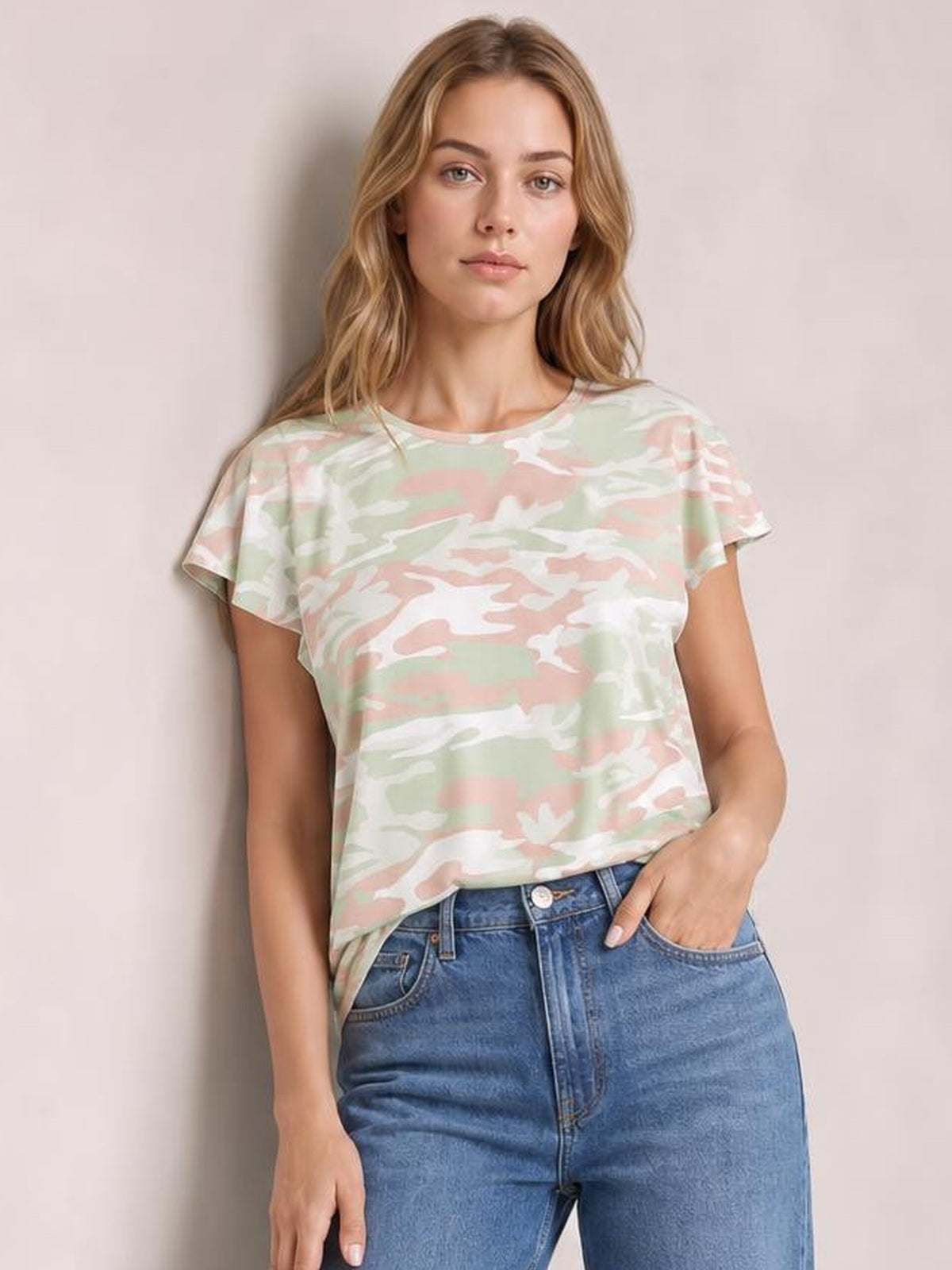 Model wears a pastel green, pink, and white printed round neck short sleeve T-shirt with a relaxed silhouette and softly draped construction.