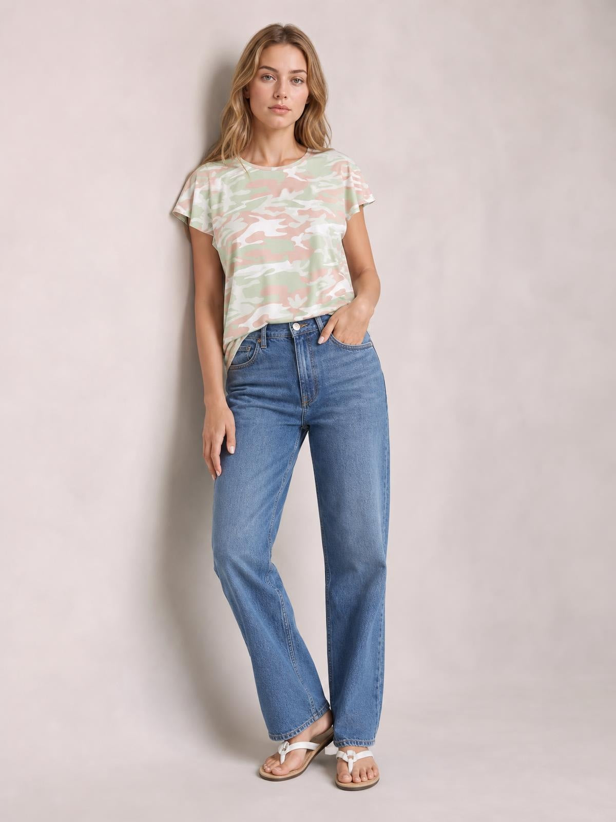 Model poses in a pastel camouflage printed round neck short sleeve T-shirt with a relaxed silhouette and slightly curved hem.