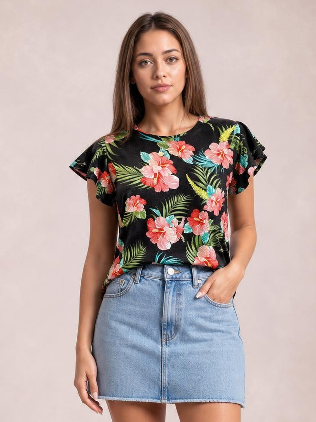 Model wears a black printed round-neck short-sleeve T-shirt with a relaxed silhouette, colorful floral and tropical leaf pattern, and rolled sleeve hems.