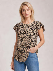 A woman wears a tan leopard-print round neck short sleeve T-shirt with a relaxed silhouette and curved hem, posing with one hand in her jeans pocket.