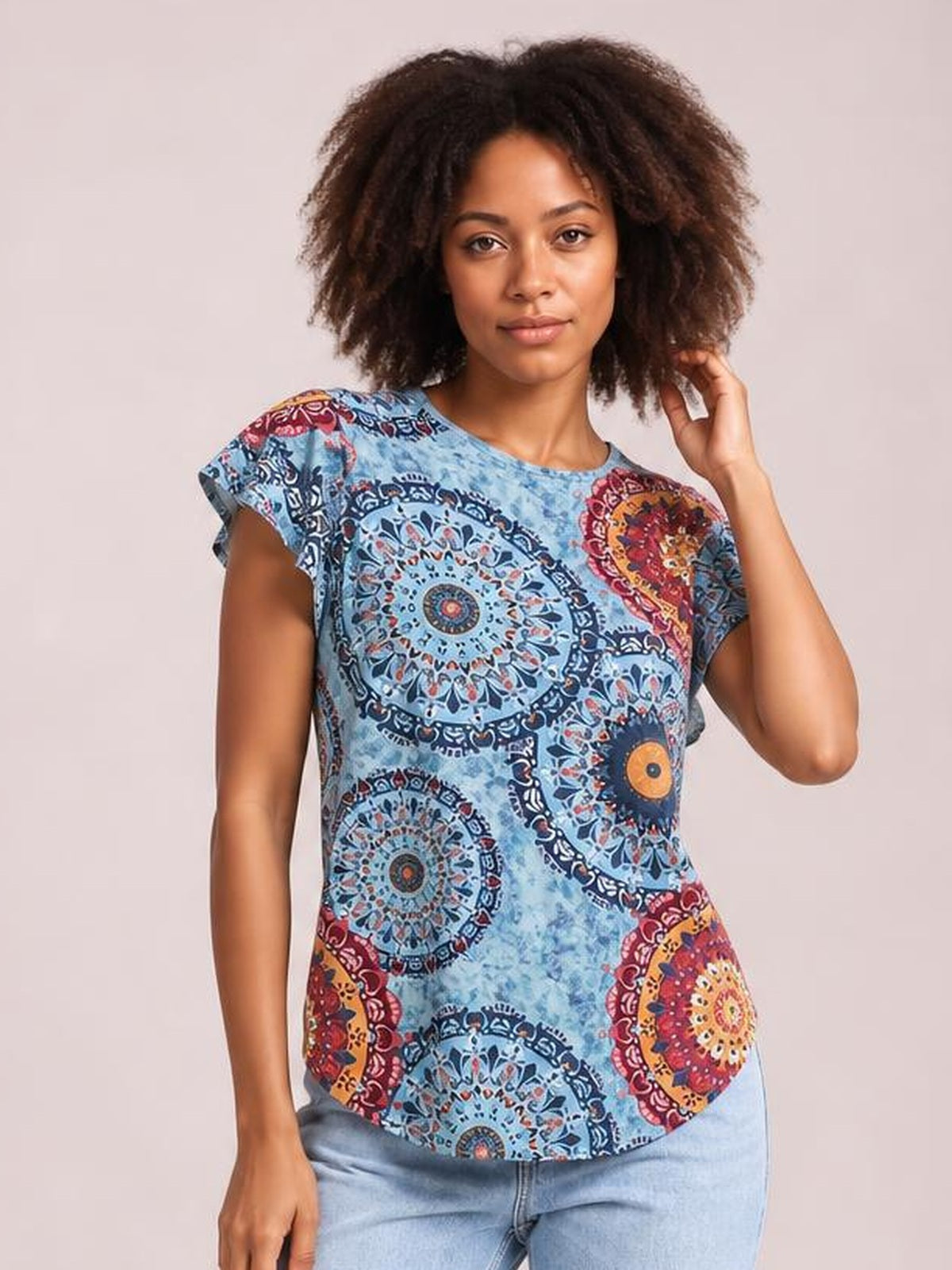 A model poses in a light blue printed round neck short sleeve T-shirt with colorful mandala motifs and a relaxed straight silhouette.