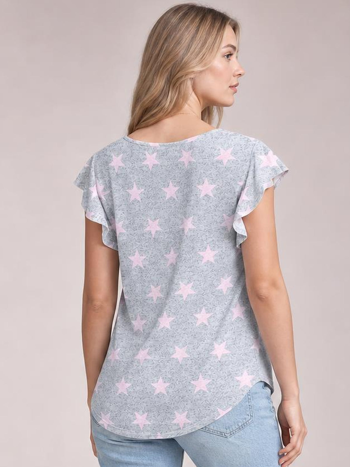 Model shown from behind wearing a gray printed round neck short sleeve T-shirt with pink stars, flutter sleeves, a relaxed silhouette, and curved hem.