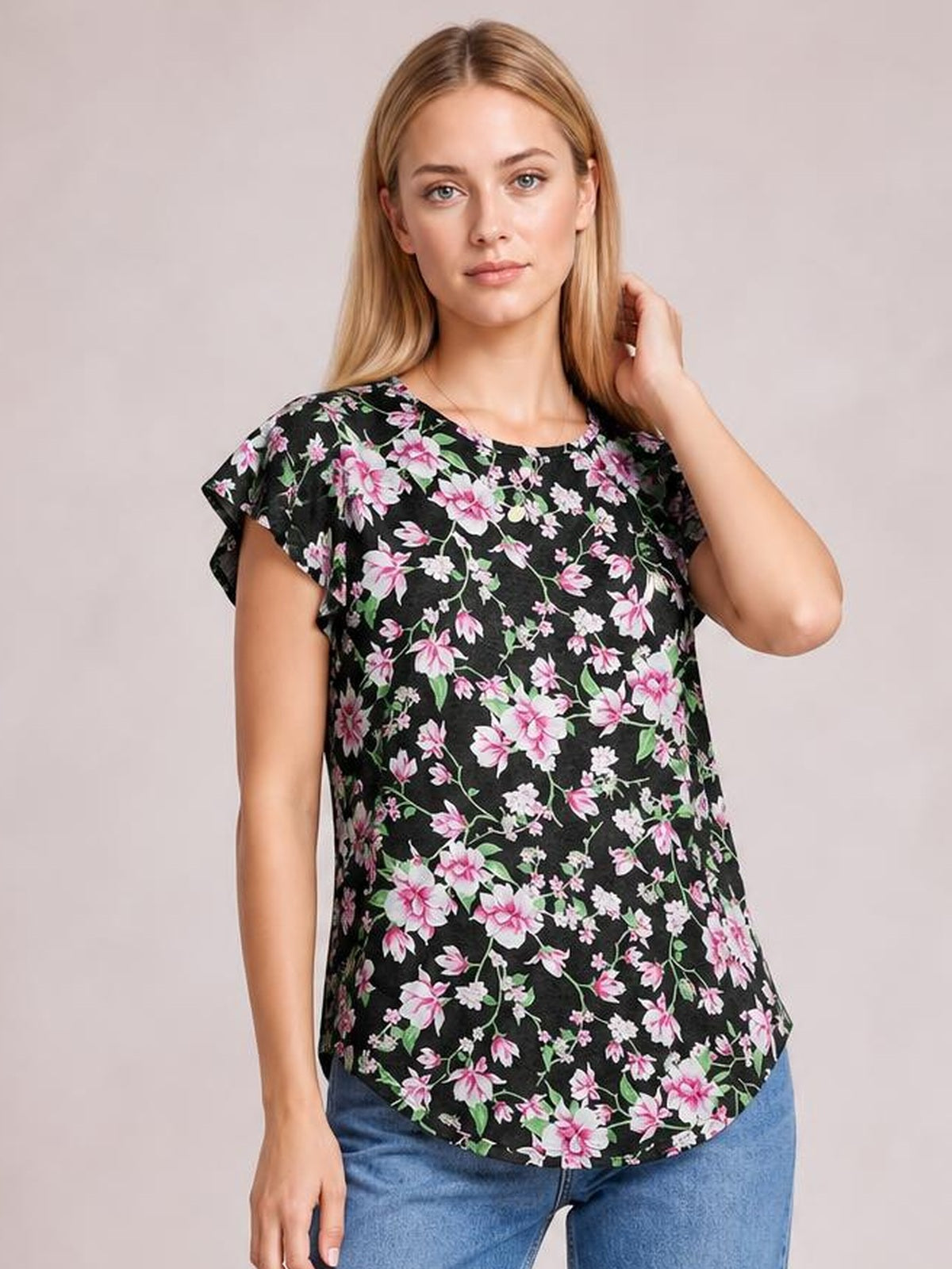 Model poses in a black floral printed round-neck T-shirt with short flutter sleeves, a relaxed silhouette, and a curved hem.