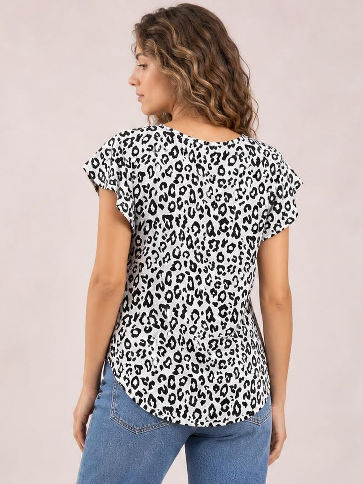 A model looks over her shoulder wearing a white and black leopard-print round-neck short-sleeve T-shirt with a relaxed silhouette and curved hem.