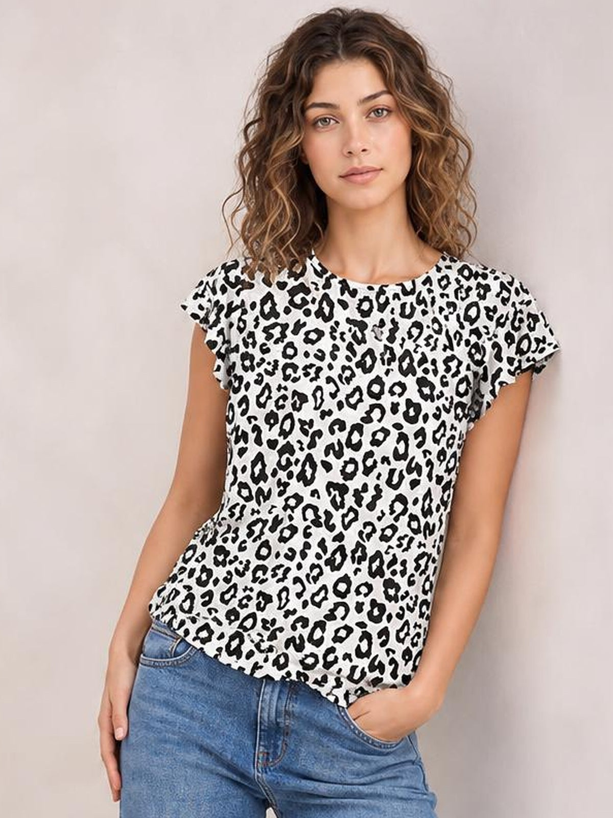 Model wearing an opaque white printed round neck short sleeve T-shirt with a relaxed straight silhouette and black leopard pattern, paired with jeans.
