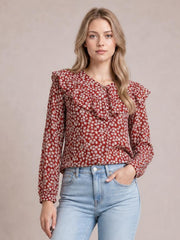 A model poses in a red floral long-sleeve blouse with a statement ruffled collar, relaxed straight silhouette, and softly gathered shoulder details.