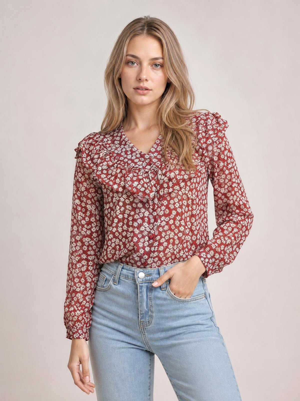 Model wearing a burgundy printed long-sleeve blouse with a floral pattern, V-neckline, gathered shoulder details, and a relaxed silhouette with one hand in her pocket.