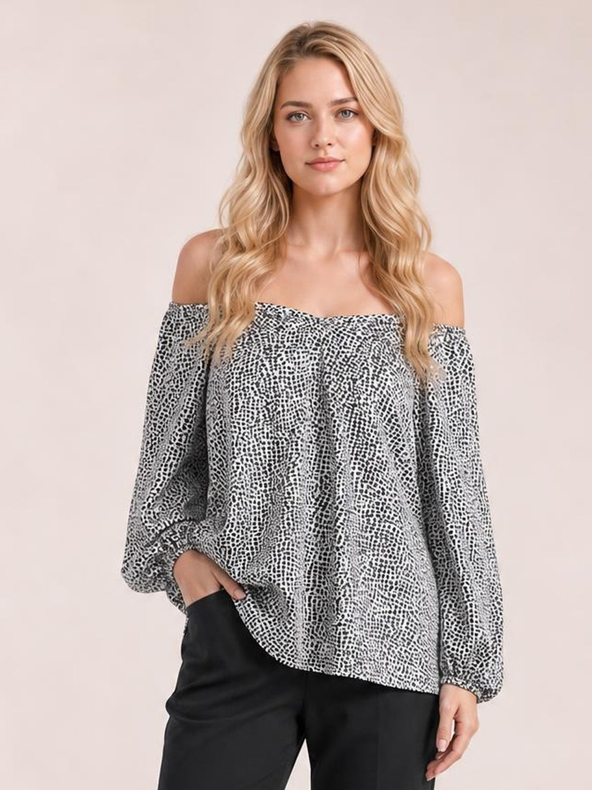 A model poses in a black-and-white printed blouse with an off-shoulder neckline, long balloon sleeves, and a relaxed, flowing silhouette.