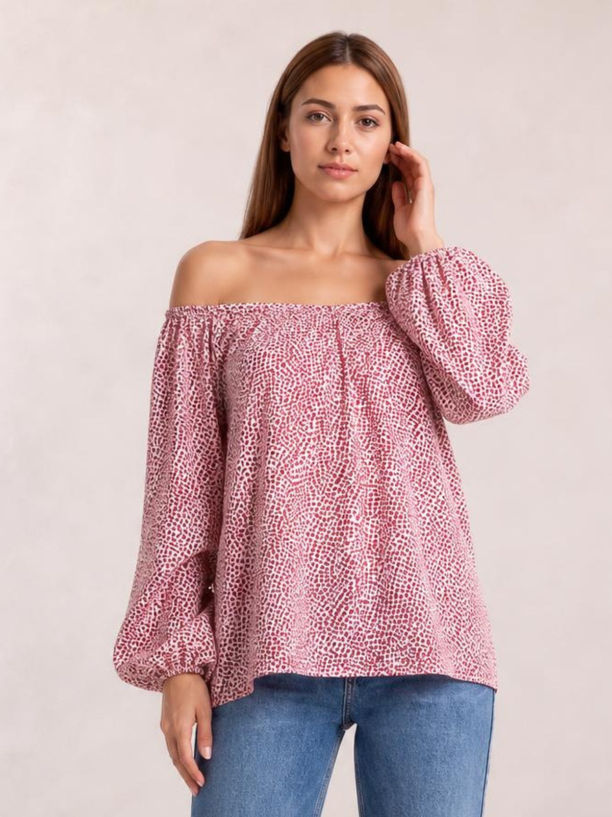 A model poses in a pink printed blouse with an off-shoulder neckline, long balloon sleeves, gathered cuffs, and a loose, long silhouette.