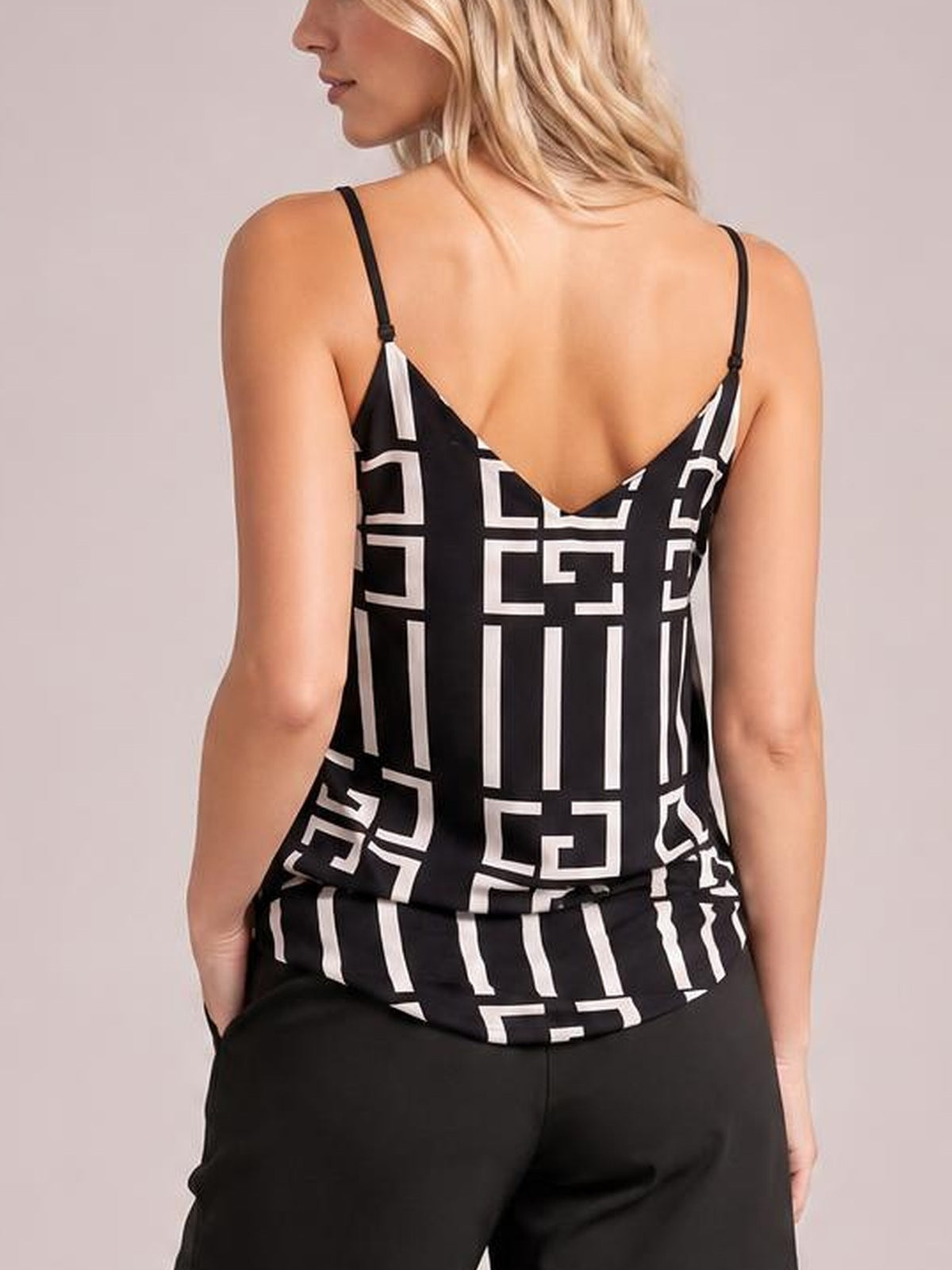 Model seen from behind wearing a black-and-white printed V-neck cami with thin adjustable straps, a relaxed silhouette, and geometric patterning.
