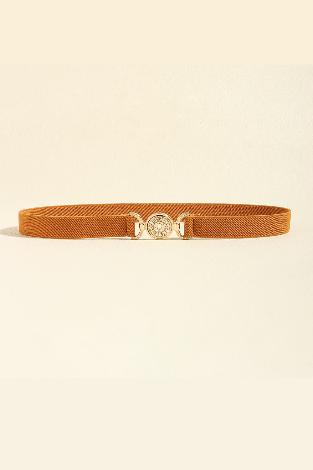 A slim brown PU leather belt lies flat, featuring a streamlined silhouette and polished round alloy buckle with decorative detailing.