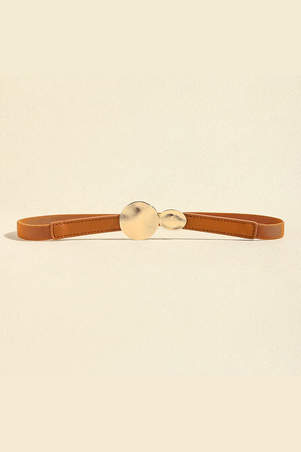 Slim brown PU leather belt with a stitched strap and sculptural alloy buckle featuring two rounded, softly textured discs.