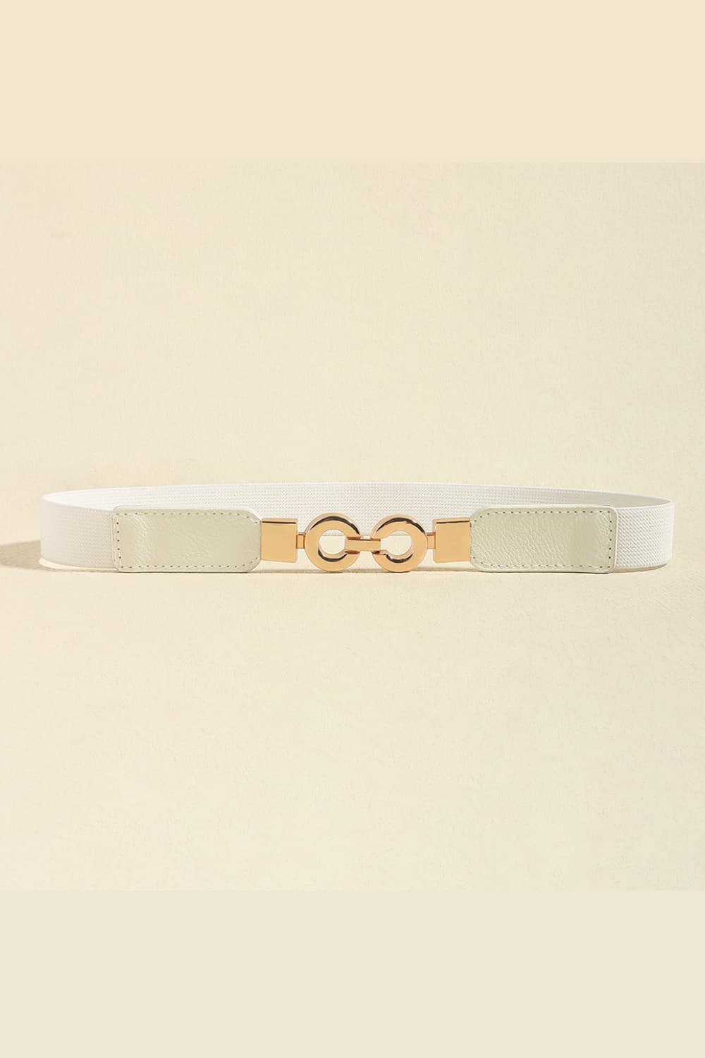 White PU leather belt with a slim 1-inch profile, smooth structured panels, and a distinctive gold-tone alloy buckle featuring two linked circular elements.
