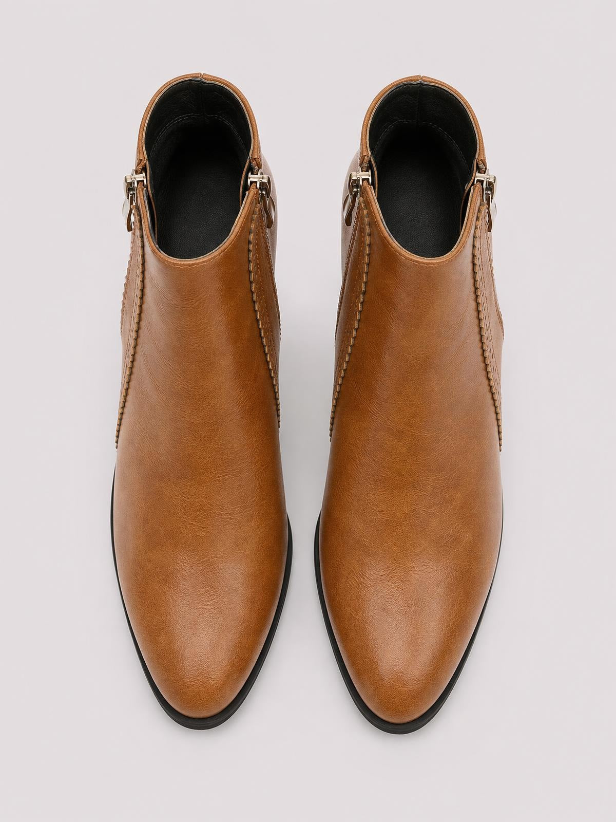 Brown PU leather ankle boots with rounded toes, black interiors, visible stitched panels, side zippers, and black rubber soles.
