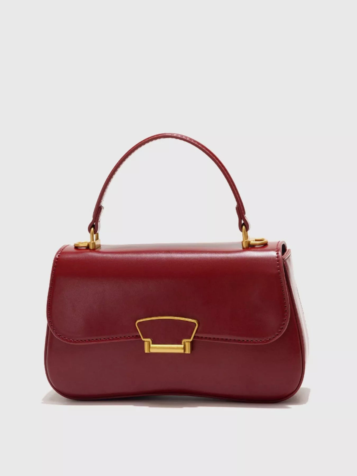 Small burgundy PU leather crossbody bag with a structured rectangular silhouette, rounded edges, top handle, stitched flap, and gold-tone clasp hardware.