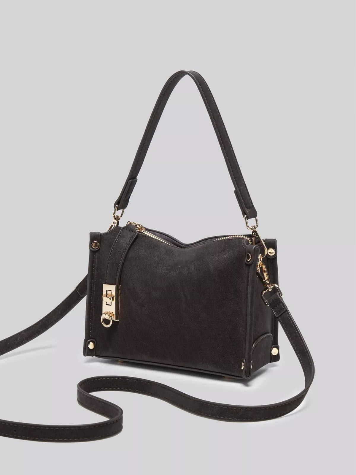 Small black PU leather crossbody bag with a structured silhouette, zip-top closure, gold-tone hardware, and an adjustable long strap.